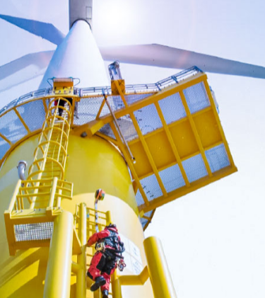 Engineers climbing wind turbine in bright sunshine