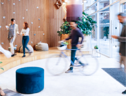 Bike commuter arriving to a busy office lobby