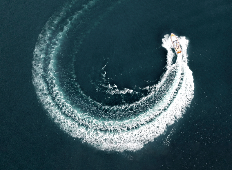 Boat circling making a wake in water