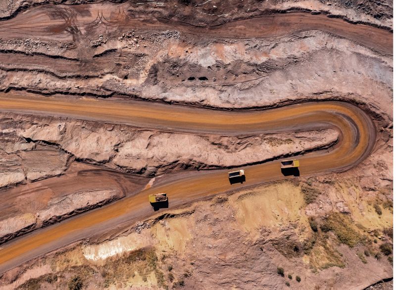 Overhead view of dump trucks on curved road