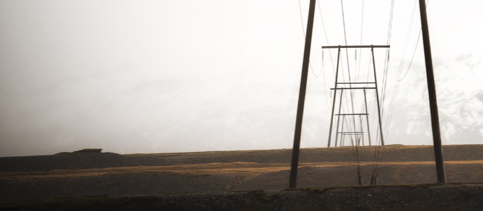 Decorative. Power lines stretching into the distance across a foggy landscape