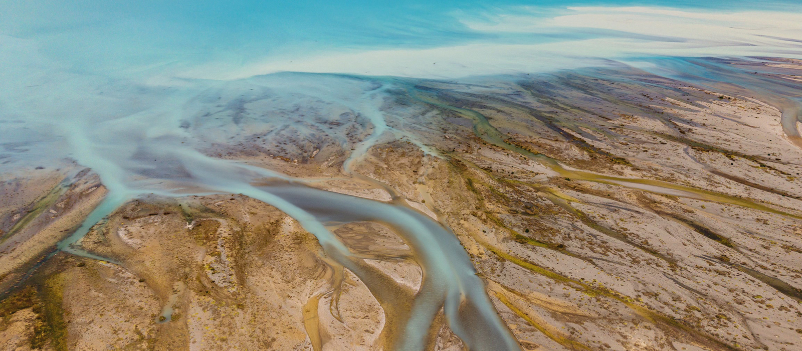 Decorative. Aerial view of winding river channels cutting through a dry, sandy terrain