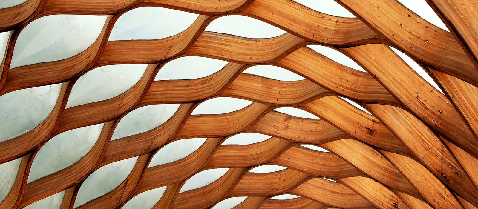 Decorative. Close-up of an interwoven wooden structure secured by small metal rivets.