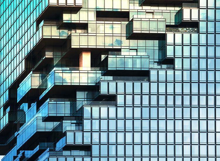 Decorative. Contemporary glass building with staggered balconies and reflective windows.